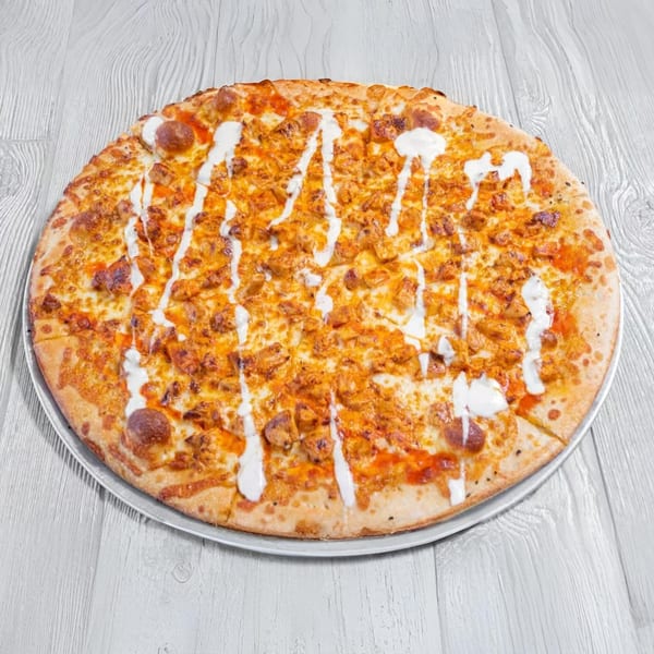 Marc's Pizzeria and Grill's buffalo chicken pizza with white sauce drizzle on a metal pan.
