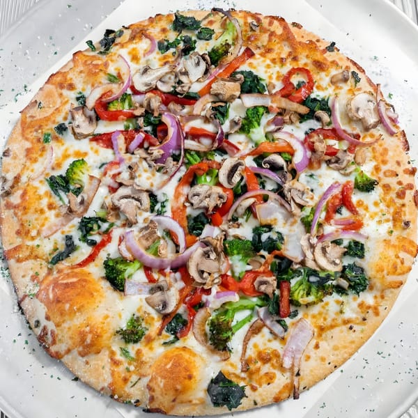 A Marc's Pizzeria and Grill white pizza with mushrooms, red onions, broccoli, and spinach.