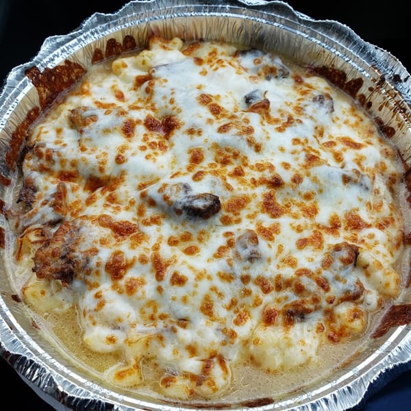 Baked pasta dish with melted cheese and sausage in a foil takeout container from Marc's Pizzeria.